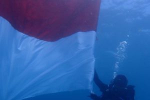 77 Penyelam Kibarkan Bendera Merah Putih di Dalam Perairan Taman Laut Pandanan Lombok