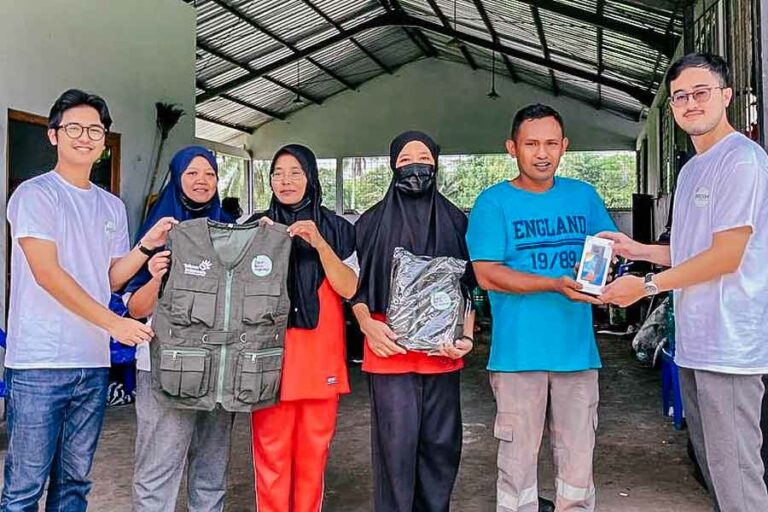 Hadapi Problem Sampah dan Lingkungan, Telkom Sodorkan Program Bresih Awak Telkom Magelang, inisiator Program Bresih, sedang menyerahkan rompi operasional kepada petugas TPS Desa Tuksongo