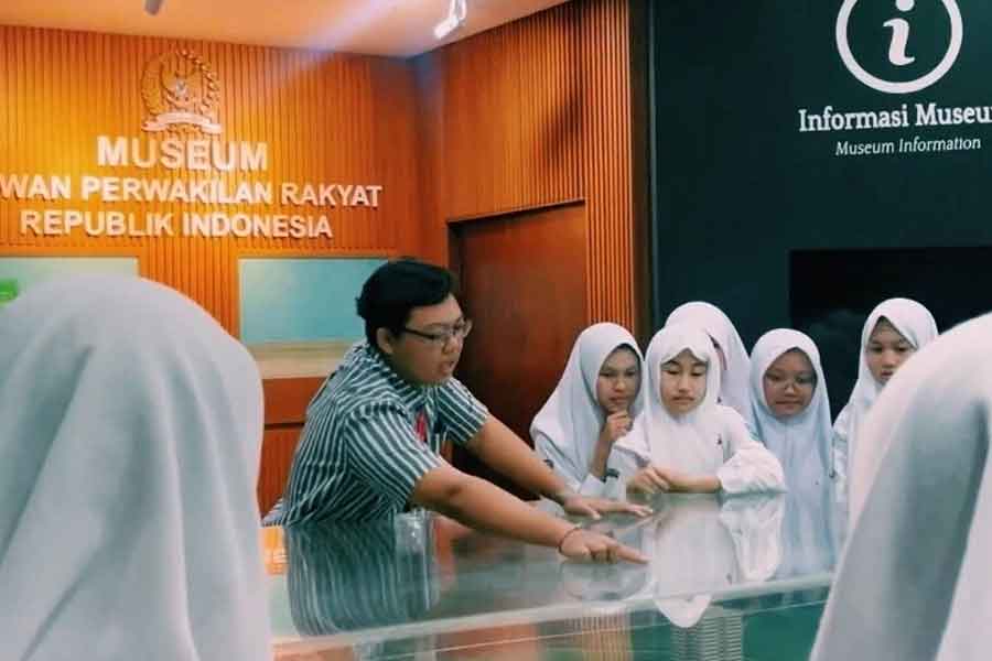 Dharma sedang memandu pengunjung Museum DPR RI.
