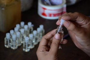 Serba-serbi Parfum Eceran, Cari Bahan Dasar yang Aman untuk Kesehatan Pelanggan ikut mengatur botol kecil yang berisi bibit parfum. (foto: Anton Kusnanto, pilar.id)