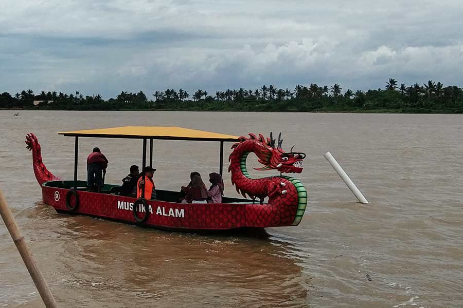 Pengunjung menjelajah Muara Opak dengan perahu naga yang bisa digunakan dengan biaya Rp 15 ribu per orang (foto: Rizki Liasari, pilar.id)