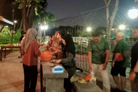 Anggota komunitas Awoiwoi saat menyiapkan menu buka makan di tempat bagi pengguna jalan di sekitaran Taman Nganggel, Surabaya, Minggu (16/4/2023)