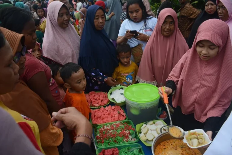 Warga mengantri untuk bisa menikmati menu ketupat, saat digelar tradisi kupatan di Kampung Sukolilo Surabaya. (foto: Anton Kusnanto, pilar.id)