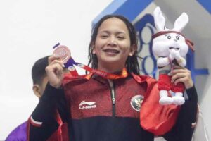 Angel Gabriel Yus memamerkan medali perunggu yang dia peroleh dari nomor 100 meter backstroke atau gaya punggung di SEA Games 2023 Kamboja (foto: kemenpora)