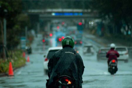Pengendara motor melaju di tengah hujan di Jakarta (foto: Sabda Rhamadhoni, unsplash)