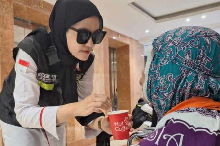 Salah satu petugas menyuapi jemaah haji lansia dengan minuman full cream (foto: Dok Kemenag)