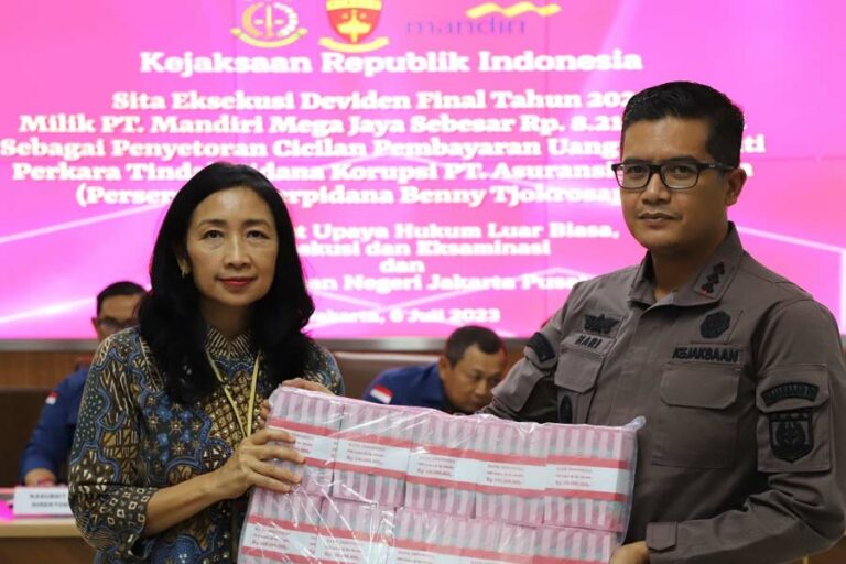 Petugas menunjukkan uang tunai senilai Rp 8.216.084.561, hasil Deviden Final Tahun Buku 2022 dari penyitaan saham PT Mandiri Mega Jaya.