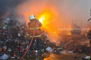 Petugas PMK sedang berusaha memadamkan kebakaran hebat di pabrik sepatu di Mojokerto (foto: dok beritajatim.com)
