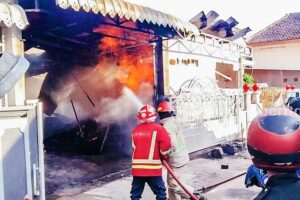 Petugas damkar saat bekerja keras memadamkan kebakaran di sebuah rumah di Jl Wijaya Kusuma Tengah, Kelurahan Cepokomulyo, Kecamatan Kepanjen, Kabupaten Malang (foto: dok beritajatim.com)