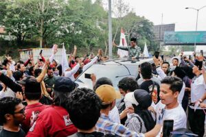Tiba di Kampung Halaman, Mahfud MD Sempatkan Berziarah dan Silaturahmi dengan Ulama Mahfud MD yang berada di mobilnya, lantas menyapa para pendukungnya sambil mengacungkan salam tiga jari