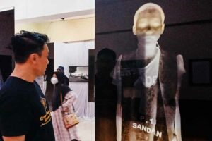Pengunjung sedang melihat Au Loim Fain, rangkaian foto karya Romi Perbawa yang disajikan Stikosa AWS Photo Week 2023