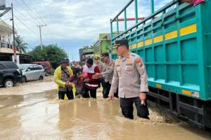 Kapolres Sidrap AKBP Erwin Syah bersama Wakapolres Kompol Ahmad Rosma, PJU dan PMI membantu evakuasi masyarakat terdampak banjir di Dua Pitue, Sidrap (foto: Dok Humas Polri)