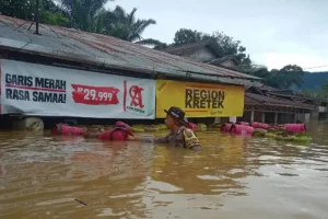 Petugas Bhabinkamtibmas Polsek Air Besar saat berupaya menerjang banjir untuk melakukan evakuasi warga terdampak banjir bandang (foto: Dok Humas Polri)