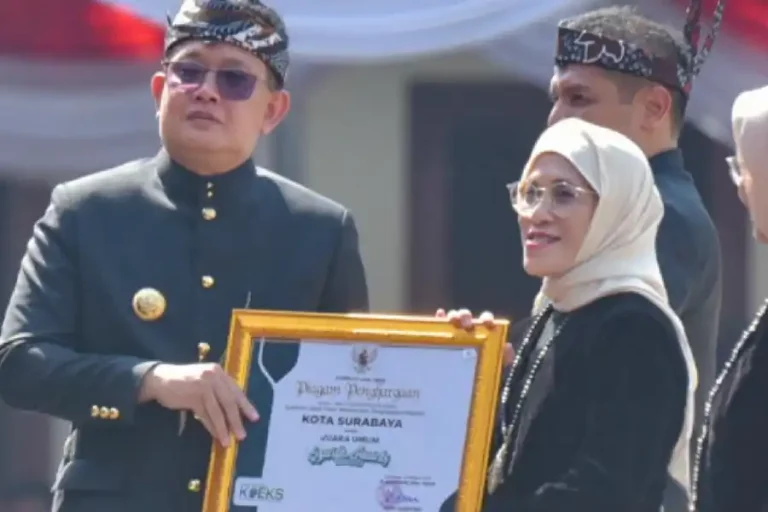 Pj Gubernur Jawa Timur Adhy Karyono saat menyerahkan penghargaan kepada Pj Wali Kota Surabaya, Restu Novi Widiani.