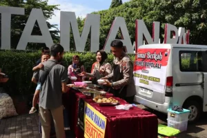 Pasutri Polri, IPTU Agung Muryo dan Bripka Sab’atun Hasanah, sedang membagikan makan gratis