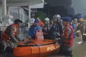 Petugas Brimob Polda Metro Jaya membantu proses evakuasi warga terdampak banjir di kawasan Perumahan Gardenia Estate, Ciputat, Tangerang Selatan