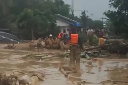 Prajurit TNI mengevakuasi warga saat banjir merendam Batangtoru, Tapanuli Selatan. Evakuasi dilakukan di medan berat dengan koordinasi lintas instansi.