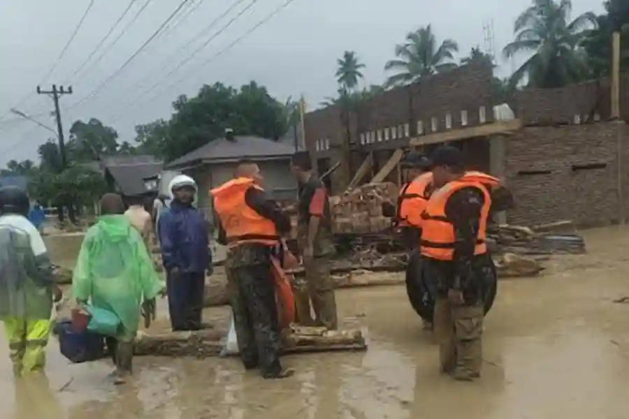 Prajurit TNI mengevakuasi warga saat banjir merendam Batangtoru, Tapanuli Selatan. Evakuasi dilakukan di medan berat dengan koordinasi lintas instansi.